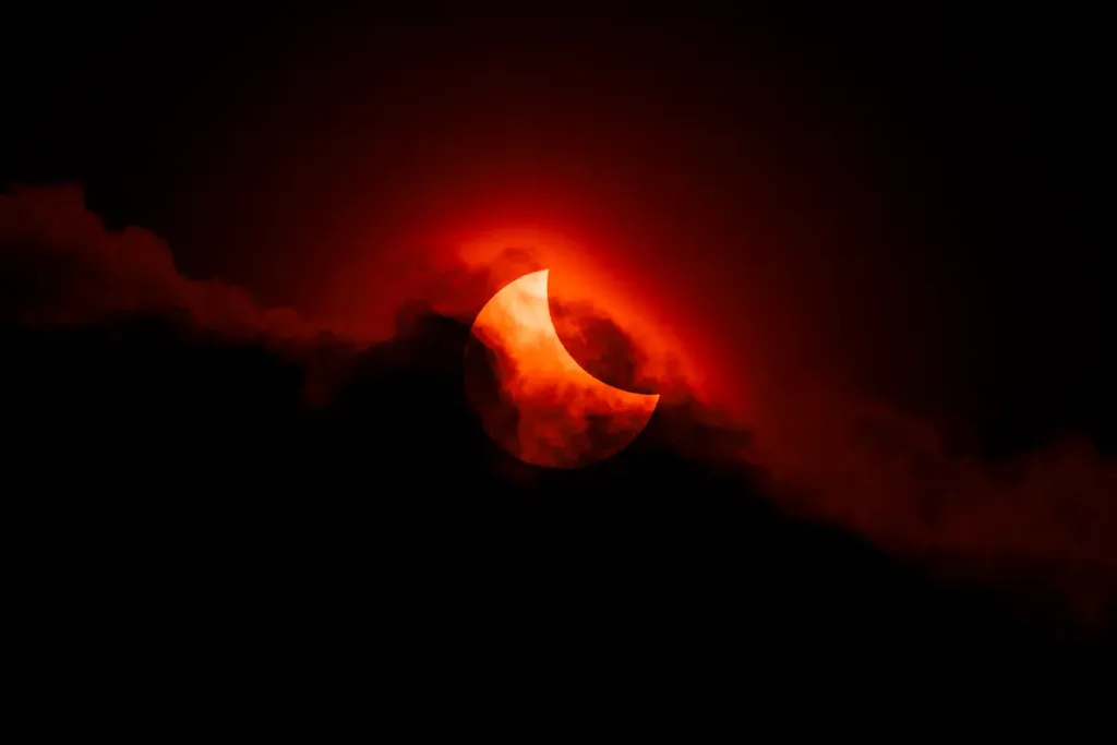 the 2025 partial eclipse is seen as clouds almost block the sun creating a spectacular and blood coloured spectacle l