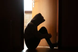 SilhouetteOfPersonSittingInBathroomDoorFrame