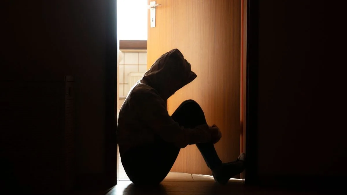 SilhouetteOfPersonSittingInBathroomDoorFrame
