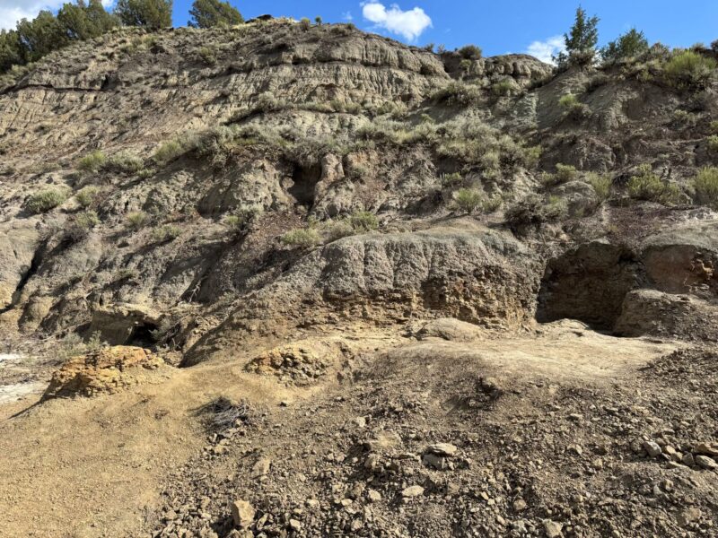 نمایی از صخرهها با آسمان آبی در بالا. زمین قهوهای روشنتر دارای ۴ برجستگی است.